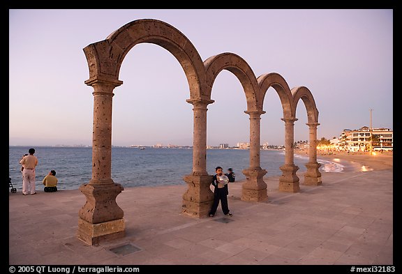 Boy standing by the Malecon arches at dusk, Puerto Vallarta, Jalisco. Jalisco, Mexico