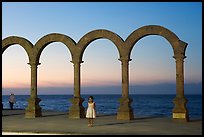 Girl standing by the Malecon arches at sunset, Puerto Vallarta, Jalisco. Jalisco, Mexico