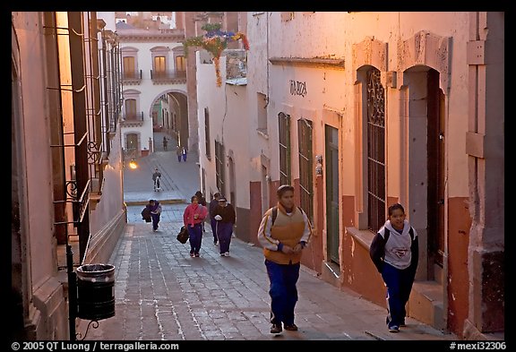 Children heading to school up a narrow cajaon, dawn. Zacatecas, Mexico