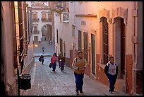 Children heading to school up a narrow cajaon, dawn. Zacatecas, Mexico