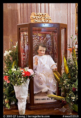 Figure of Santo Nino Del Milagro with offered flowers. Zacatecas, Mexico (color)