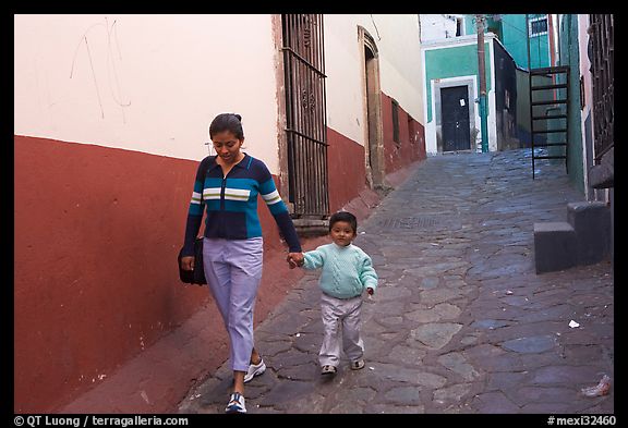 Woman and boy walking down an alleyway. Guanajuato, Mexico