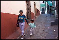 Woman and boy walking down an alleyway. Guanajuato, Mexico