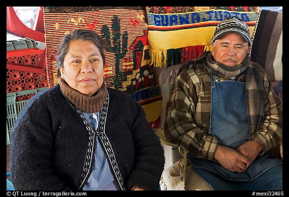 Couple sitting in front of carpets. Guanajuato, Mexico (color)