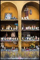 Candles, flowers, and religious offerings in a roadside chapel. Mexico