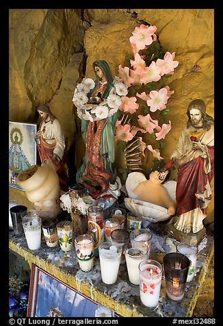 Religious figures and candles in roadside chapel. Mexico (color)