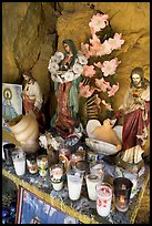 Religious figures and candles in roadside chapel. Mexico