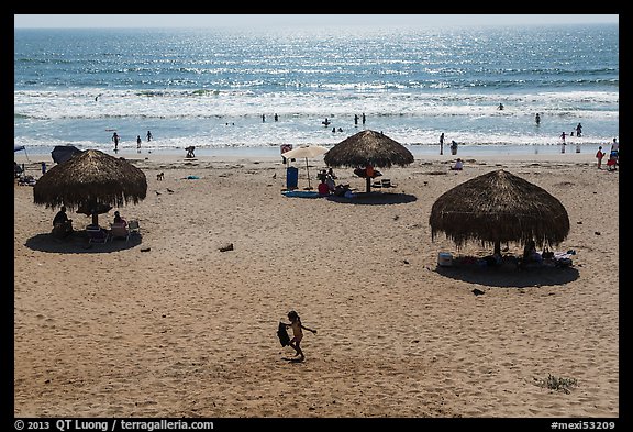 Straw sun shelter umbrellas and ocean, Ensenada. Baja California, Mexico (color)