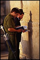 Young soldier and orthodox jew reading prayer  books at the Western Wall. Jerusalem, Israel