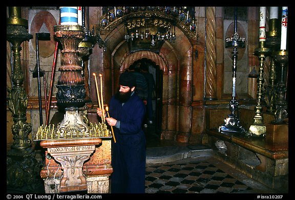 Christian Orthodox priest lighting candles. Jerusalem, Israel