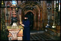 Christian Orthodox priest lighting candles. Jerusalem, Israel (color)