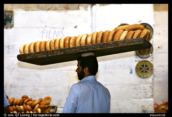 Man carrying many loafes of bread on his head. Jerusalem, Israel