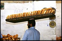 Man carrying many loafes of bread on his head. Jerusalem, Israel ( color)