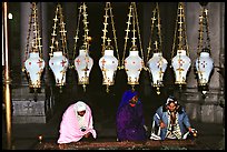 Women worshiping beneath hanging lamps inside the Church of the Holy Sepulchre. Jerusalem, Israel (color)