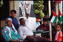 Palestinian head of family  pointing  to a mural of Yasser Arafat, Jericho. West Bank, Occupied Territories (Israel) ( color)