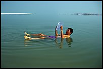 Visitor reading while floating in the Dead Sea. Israel ( color)