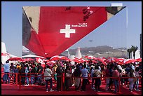 Visitors with umbrellas and reflection, Swizerland Pavilion. Expo 2020, Dubai, United Arab Emirates ( color)
