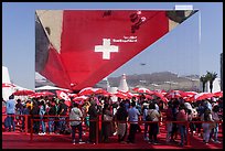 Visitors with umbrellas and reflection, Swizerland Pavilion. Expo 2020, Dubai, United Arab Emirates ( color)