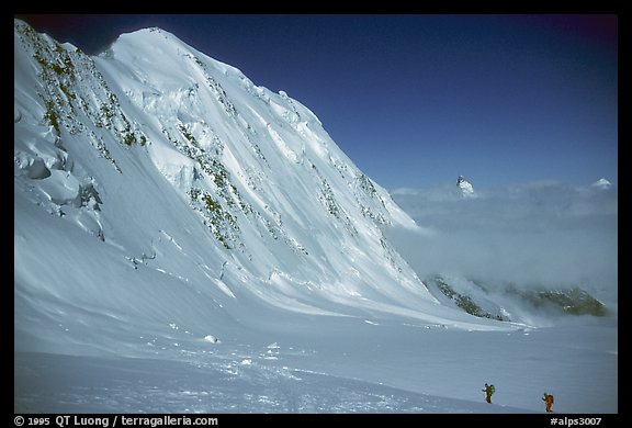 Backcountry skiers dwarfed by Liskam, Switzerland.  (color)