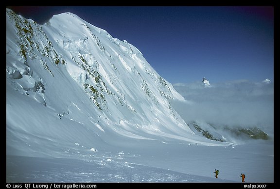 Backcountry skiers dwarfed by Liskam, Switzerland.