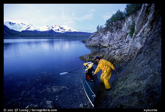 Kayaker pulling on shore at midnight, Muir Inlet. Glacier Bay National Park, Alaska (color)