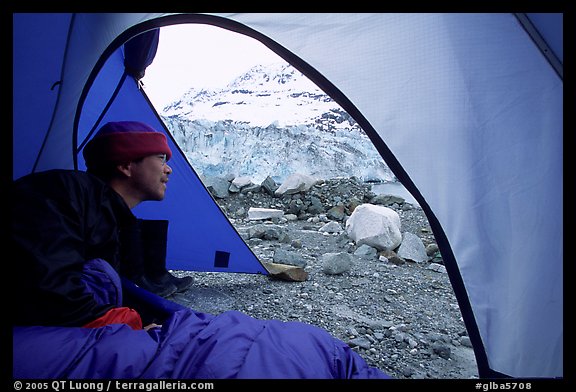 Visitor in  tent looking outside to Lamplugh Glacier. Glacier Bay National Park, Alaska (color)