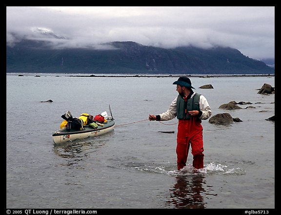 Kayaker tows kayak near Scidmore Bay. Glacier Bay National Park, Alaska (color)