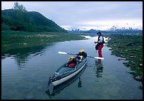 Kayaker tows kayak into a shallow tidal channel into Scidmore Bay. Glacier Bay National Park, Alaska ( color)
