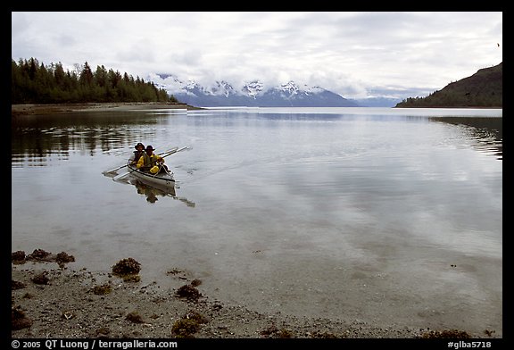 Kayakers paddle a double kayak in Hugh Miller Inlet. Glacier Bay National Park, Alaska (color)