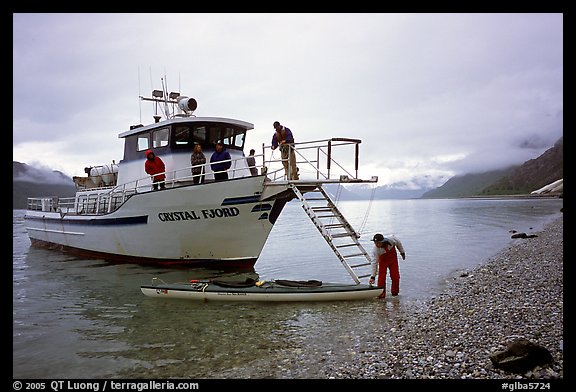 Kayaker retrieving kayak after drop-off. Glacier Bay National Park, Alaska (color)