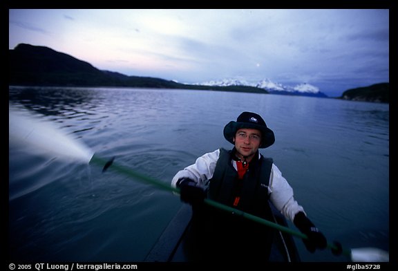 Kayaker paddling in Muir Inlet at midnight. Glacier Bay National Park, Alaska (color)