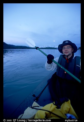 Kayaker paddling in Muir Inlet at midnight. Glacier Bay National Park, Alaska