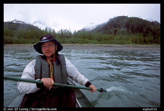 Kayaker paddling away from shore in Muir Inlet. Glacier Bay National Park, Alaska