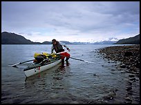 Kayaker getting into the kayak,  Muir Inlet. Glacier Bay National Park, Alaska