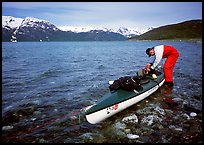 Kayaker tying up gear on top of the kayak,  East Arm. Glacier Bay National Park, Alaska