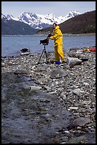 Large format photographer wearing kayaking gear on a beach in East Arm. Glacier Bay National Park, Alaska