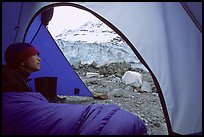 Camper lying in sleeping bag looks at Lamplugh Glacier. Glacier Bay National Park, Alaska (color)