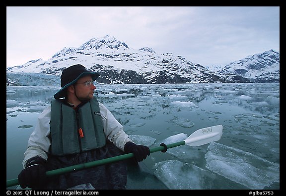 Kayaker pausing amongst icebergs near John Hopkins Inlet. Glacier Bay National Park, Alaska