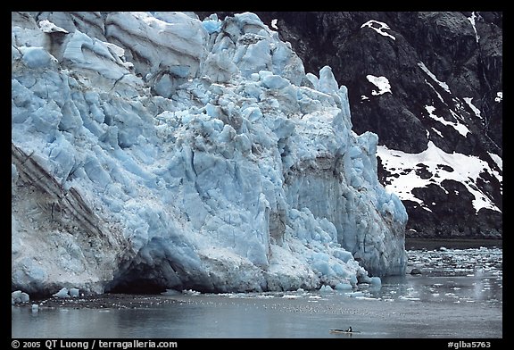 Kayaker paddling bellow Lamplugh Glacier. Glacier Bay National Park, Alaska (color)