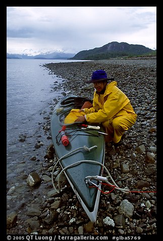 Kayaker unloading kayak. Glacier Bay National Park, Alaska (color)