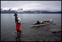 Kayaker towing kayak, East arm. Glacier Bay National Park, Alaska (color)