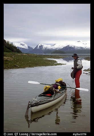 Kayaker standing in Scidmore Bay next to a shallow tidal channel. Glacier Bay National Park, Alaska (color)