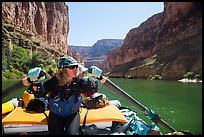 Woman rows raft on calm section of Colorado River, Marble Canyon. Grand Canyon National Park, Arizona