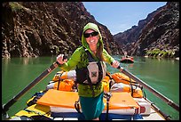 Woman standing on raft to paddle raft with oars. Grand Canyon National Park, Arizona ( color)