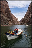 Dory boat labeled Grand Canyon carrying passengers on the Colorado River between Granite Gorge high canyon walls. Grand Canyon National Park, Arizona ( color)