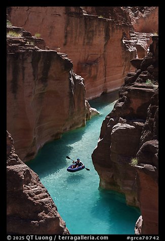 Inflatable kayak floating in clear turquoise water through a narrow canyon of Havasu Creek. Grand Canyon National Park, Arizona (color)