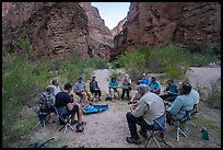 Group of Grand Canyon rafters eating a meal together on folding chairs at the National Canyon campsite. Grand Canyon National Park, Arizona ( color)