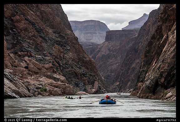 Oar-powered raft follows a flotilla through a dramatic canyon corridor in the Granite Gorge. Grand Canyon National Park, Arizona (color)