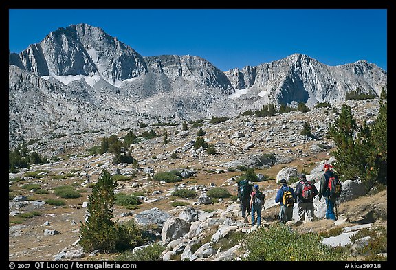 Hikers on alpine terrain and Mt Giraud range, Dusy Basin. Kings Canyon National Park, California