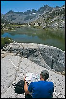 Hiker looking at map in front of lake, lower Dusy Basin. Kings Canyon National Park, California (color)